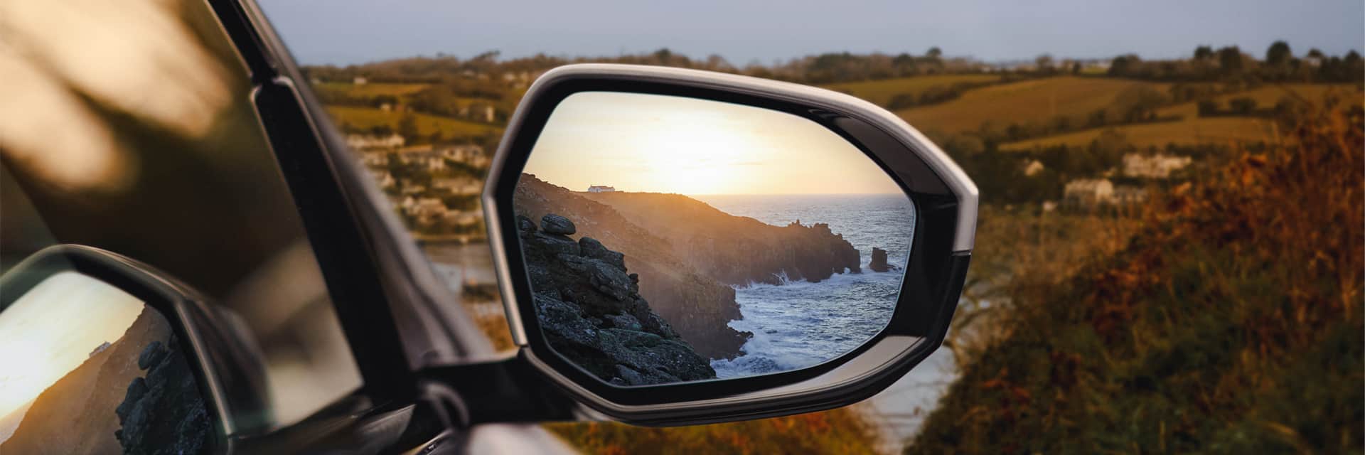 Cornwall coastline in BMW i5 wing mirror.