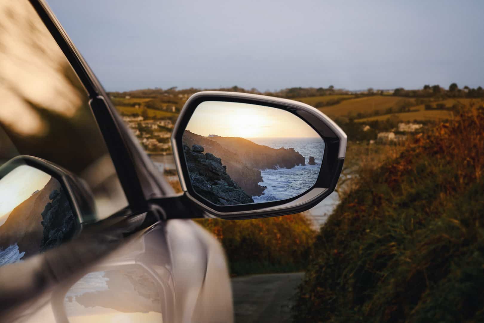Cornish coastline pictured in BMW i5 wing mirror.